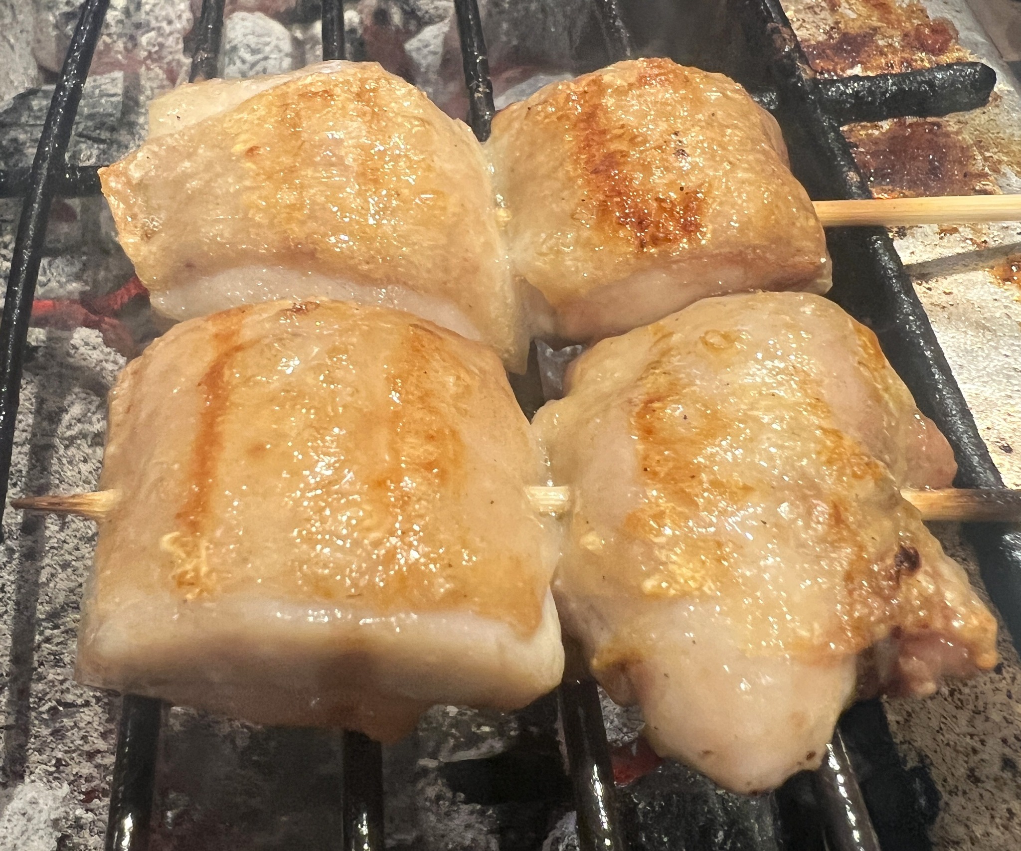 炭の熾りと煙が伝わる焼き台の焼き鳥